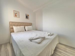 a white bedroom with a bed with white sheets at Rooftop Apart with Sea View in Kalkan Center in Kas