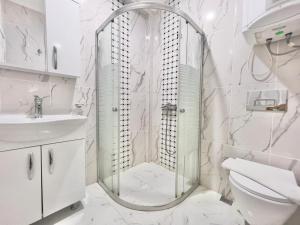 a bathroom with a shower with a toilet and a sink at Rooftop Apart with Sea View in Kalkan Center in Kas +18 photos