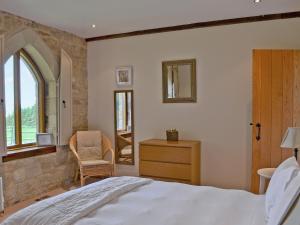 a bedroom with a bed and a chair and a window at The Water Castle in Wall Houses