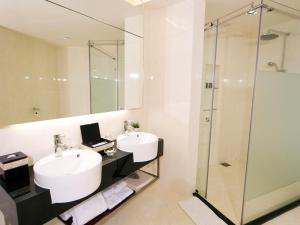 a bathroom with two sinks and a shower at Resorts World Genting - Genting Grand in Genting Highlands