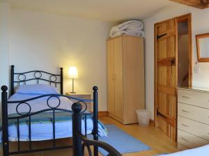 ein Schlafzimmer mit einem Bett und einer Kommode in der Unterkunft Granary Cottage in Oswestry