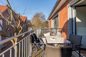 a patio with a table and chairs on a balcony at Wittehuus Wohnung 6 in Borkum +6 photos