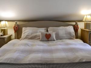 a bed with a heart pillow on top of it at Apple Loft in Hotham