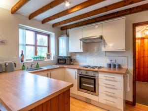 a kitchen with white cabinets and a counter top at Maybeck Cottage in Whitby