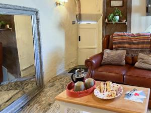 a living room with a couch and a table with a bowl of food at Cobble Cottage in Instow