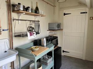 a small kitchen with a table and a microwave at Cobble Cottage in Instow