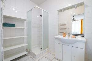 Un baño blanco con lavabo y ducha. en T2 au calme - Rond Point de Vannes, en Nantes