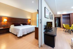 a hotel room with a bed and a desk at Sercotel Riscal in Puerto Lumbreras