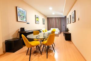 a room with a dining table and yellow chairs at Sercotel Riscal in Puerto Lumbreras