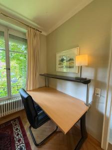 a desk in a room with a chair and a lamp at Villa Laura in Lausanne