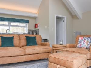 a living room with a couch and a chair at The Cottage At Stainsacre Hall in Hawsker