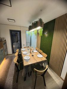 Un comedor con una mesa larga y sillas. en KUZINATRA Apartament, en Slănic-Moldova