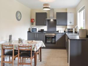 a kitchen with a table with chairs and a counter top at Five Dorchester Drive - Uk32043 in Inglewhite