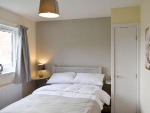 a bedroom with a bed with white sheets and a window at Five Dorchester Drive - Uk32043 in Inglewhite +8 photos