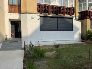 a building with a window with a gate on it at KUZINATRA Apartament in Slănic-Moldova