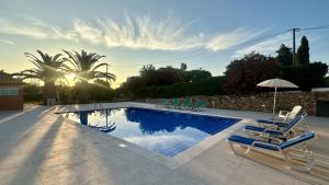 クアルテイラにあるVilla Belinha A by Check-in Portugalの椅子とパラソルのあるプール