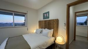 クアルテイラにあるVilla Belinha A by Check-in Portugalのベッドルーム1室(ランプ2つ、窓付)