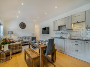 a kitchen and living room with a table and a kitchen and a couch at The Cottage in Langsett
