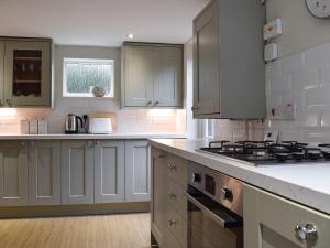 a kitchen with white cabinets and a stove top oven at The Lovely Old Cottage in Stratford-upon-Avon +14 photos
