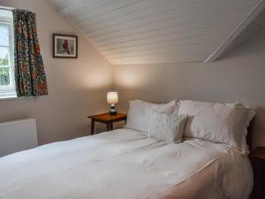 Una cama con sábanas blancas y almohadas en una habitación. en Needle House, en Ravenstonedale 22 fotos más