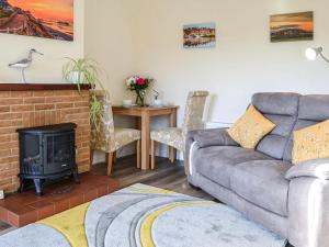 een woonkamer met een bank en een open haard bij Keepers Retreat, The Annex in Roughton