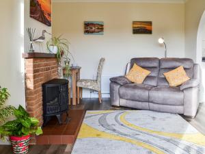 een woonkamer met een bank en een open haard bij Keepers Retreat, The Annex in Roughton