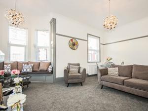 a living room with couches and a clock on the wall at Salty Towers in Saltburn-by-the-Sea