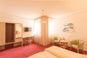 Habitación de hotel con cama, mesa y sillas en Hotel Leander, en Bitburg