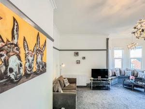 a living room with a large painting of horses on the wall at Salty Towers in Saltburn-by-the-Sea