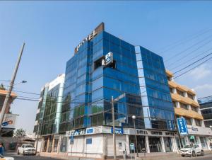 un alto edificio blu con macchine parcheggiate di fronte di Best Western Real Tula Express a Tula de Allende