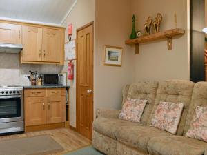 a living room with a couch and a kitchen at Printers Cottage in Ambleside