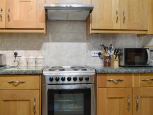 a kitchen with a stove and a microwave at Printers Cottage in Ambleside