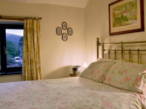 a bedroom with a bed and a window at Printers Cottage in Ambleside +10 photos