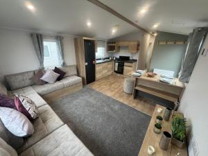 a large living room with a couch and a table at 8 Guests - Swimming Pool - 1min to the Beach in Heacham