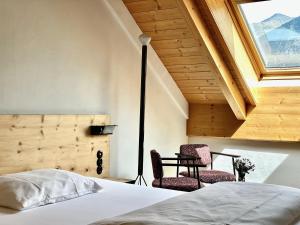 una camera con un letto e due sedie di Hotel Central La Fainera Superior a Valchava