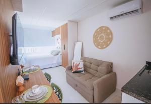 ein Wohnzimmer mit Sofa und Tisch in der Unterkunft Flat Porto de Galinhas in Porto De Galinhas