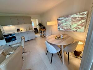 a living room with a table and a kitchen at Ula Seaview Suite 80m to the sea in Larvik