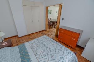 a bedroom with a bed and a dresser and a table at Check and Home - Sacoa III - 4 Huéspedes Amplio sobre la Peatonal in Mar del Plata