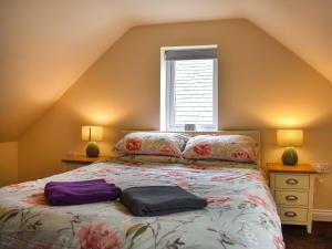 a bedroom with a bed with two lamps and a window at Winnies Cottage in Belford