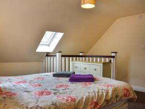 a bedroom with a bed with purple sheets and a window at Winnies Cottage in Belford