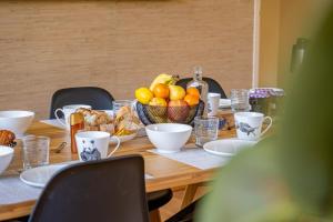 a wooden table with a bowl of fruit on it at Marc's Flat - Calm & Cosy in Nantes