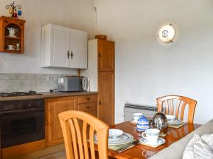 Il comprend une cuisine équipée d'une table en bois et d'un four micro-ondes. dans l'établissement Mount Cottage, à Wennington