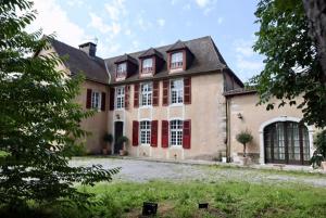 una grande casa con porte rosse e un cortile di Domaine Le Pehau 8 - Avec jardin et terrasse a Osserain-Rivareyte