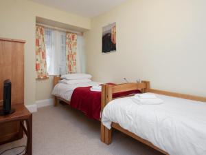 2 Betten in einem Zimmer mit einem TV und einem TV in der Unterkunft Larkrise in Kingswear + 4 Fotos