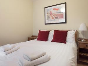 ein Schlafzimmer mit einem weißen Bett mit Handtüchern darauf in der Unterkunft Larkrise in Kingswear