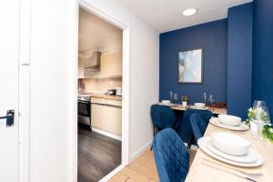 a kitchen and dining room with blue walls and a table and chairs at Open Mind Property - Cozy 2 Bed Room & Free Parking in Portsmouth