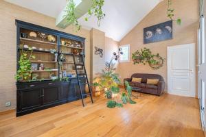 a living room with a large black cabinet with plants at Marc's Flat - Calm & Cosy in Nantes