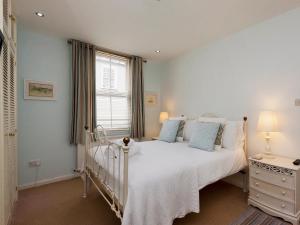 a bedroom with a white bed and a window at Snugglers Cove Apt 2 in Dartmouth
