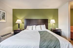 a large bed in a hotel room with two lamps at Coratel Suites in Wichita