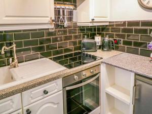 a kitchen with green tiles on the wall at Whitby Sands in Whitby
